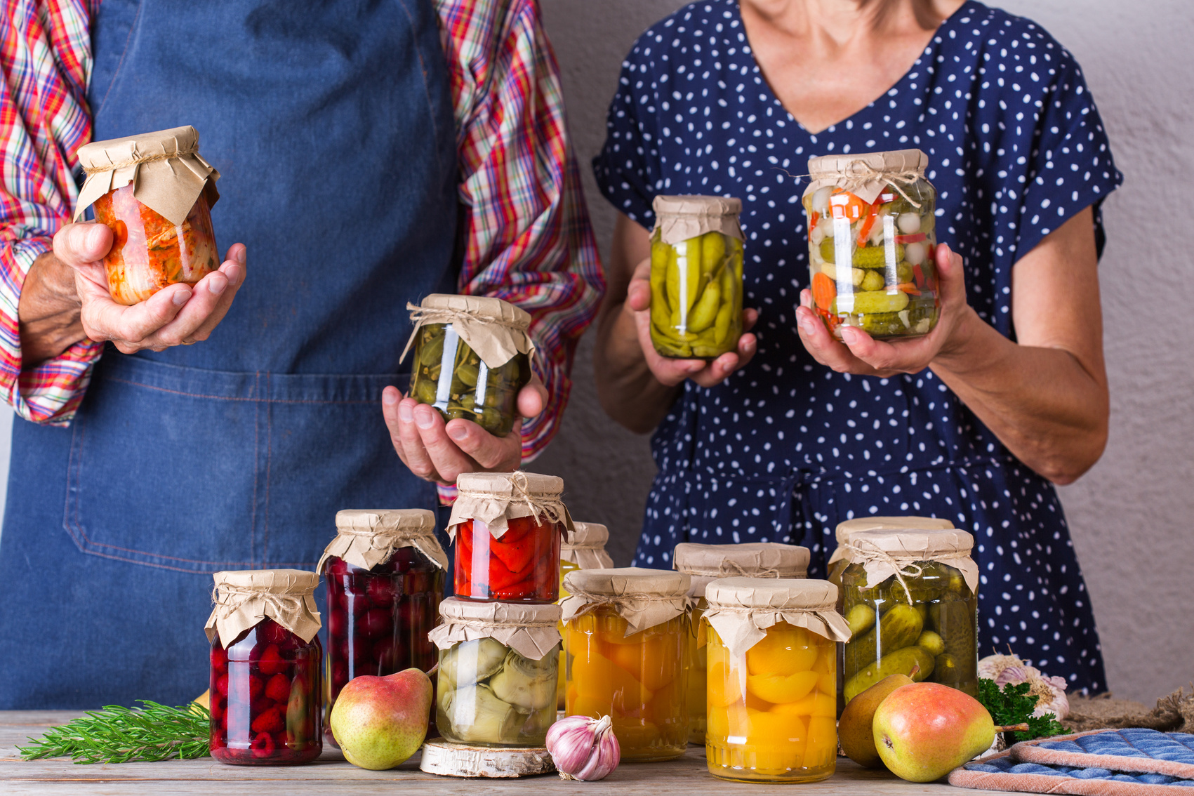 Senior Couple Holding Jars of Preserved Food
